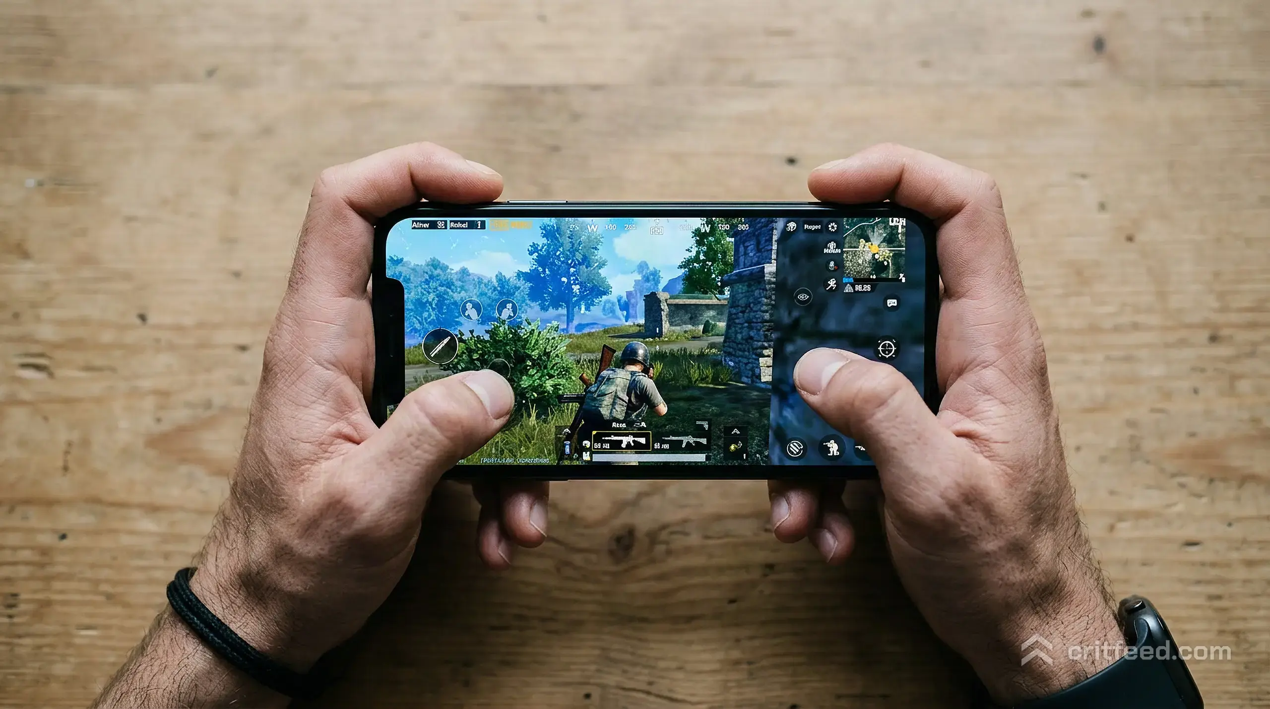 Close top-down view of two hands gripping a phone in landscape, wrists tilted slightly to one side mid-fire, index fingers